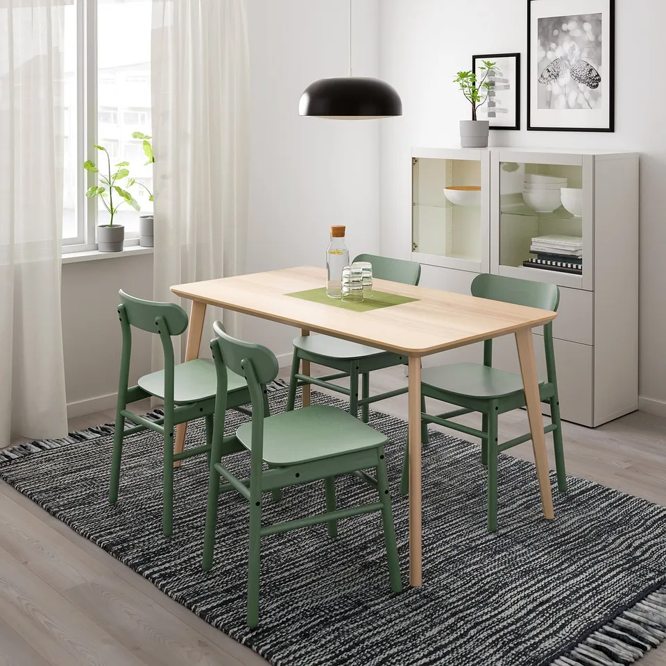 Simple modern dining set with light wood table and green chairs, perfect for small spaces.