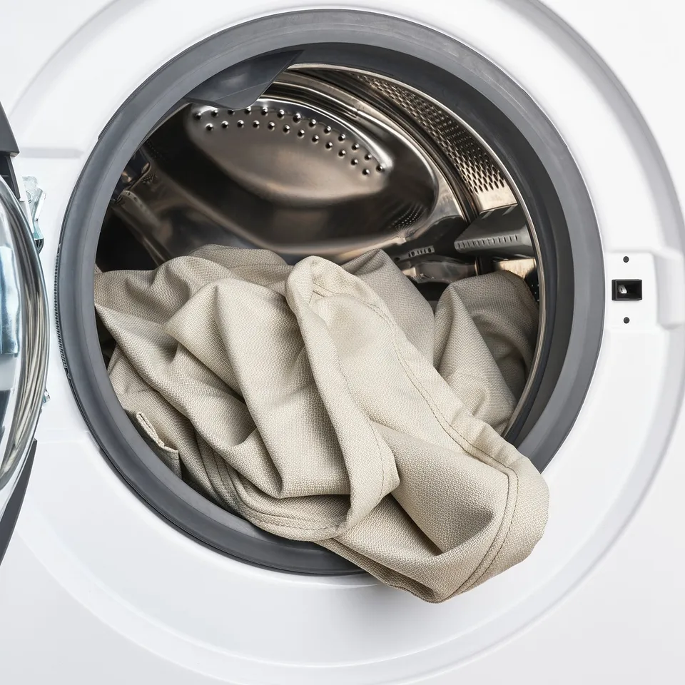 Machine washable bed cover inside open dryer, easy to clean and replace.