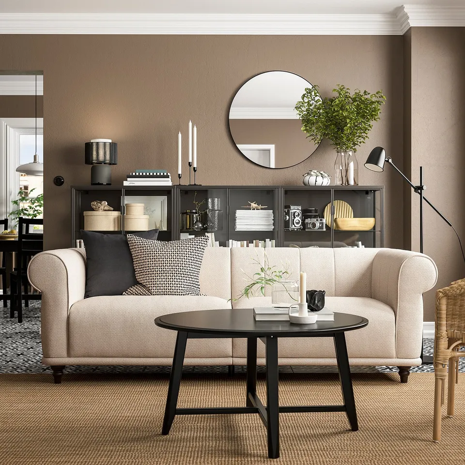 Modern living room with beige VISKAFORS sofa, black coffee table, black cabinet, and round mirror.