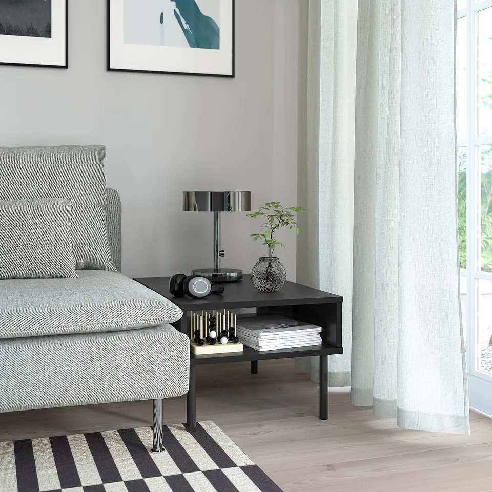 Grey sofa, striped rug, and TUNSTA coffee table with lamp, plant, and books.