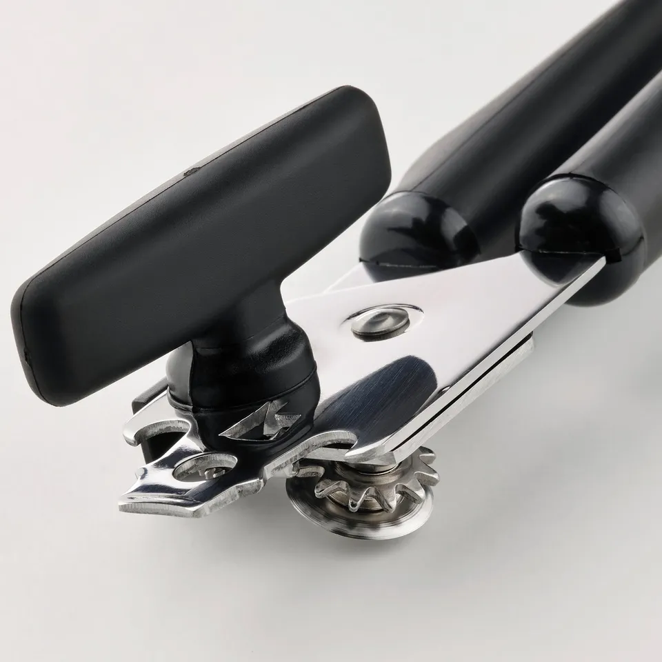 Can opener with sturdy stainless steel and ergonomic black handles, ready for precise can opening.
