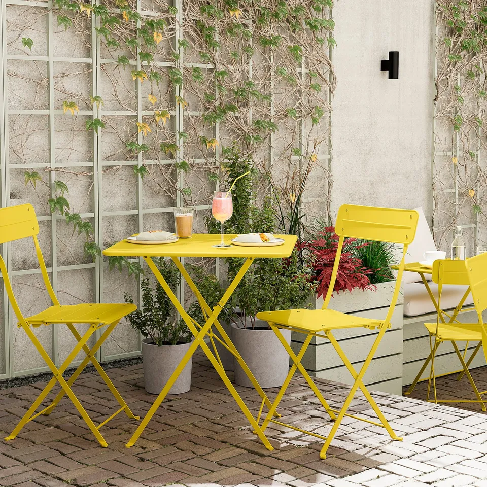 Bright yellow foldable patio set with table and chairs, perfect for small spaces. Surrounded by potted plants.