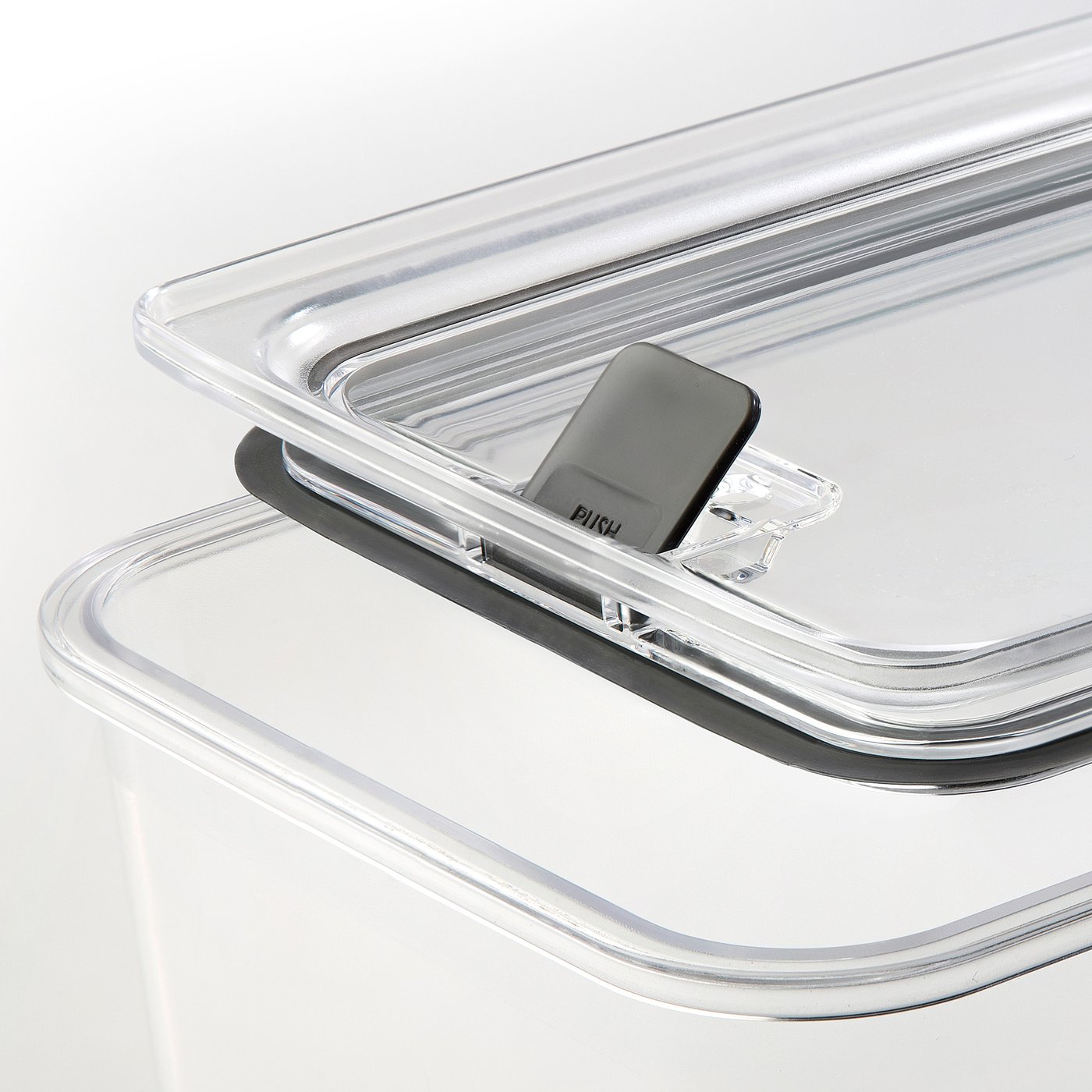 Clear stackable food jar lid, sealed with ventilation button, resting on jar, transparent for easy viewing.