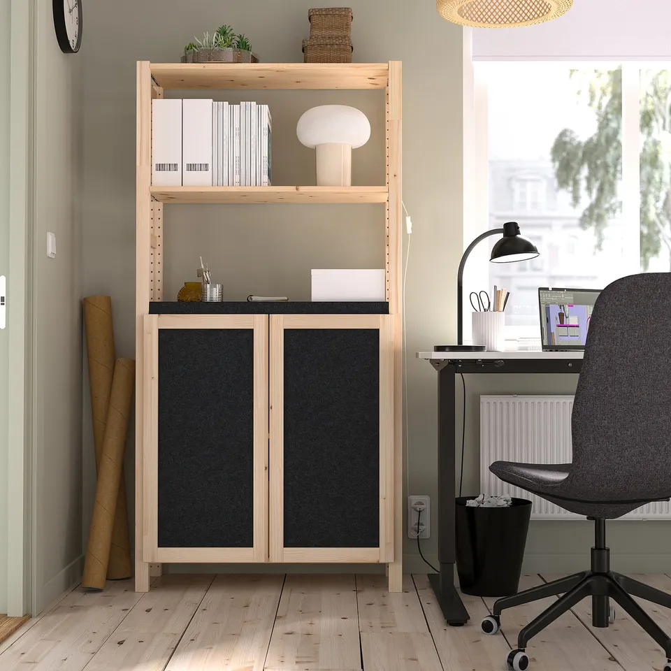 IVAR storage with black felt doors, binders, lamp, and desk with computer and chair.