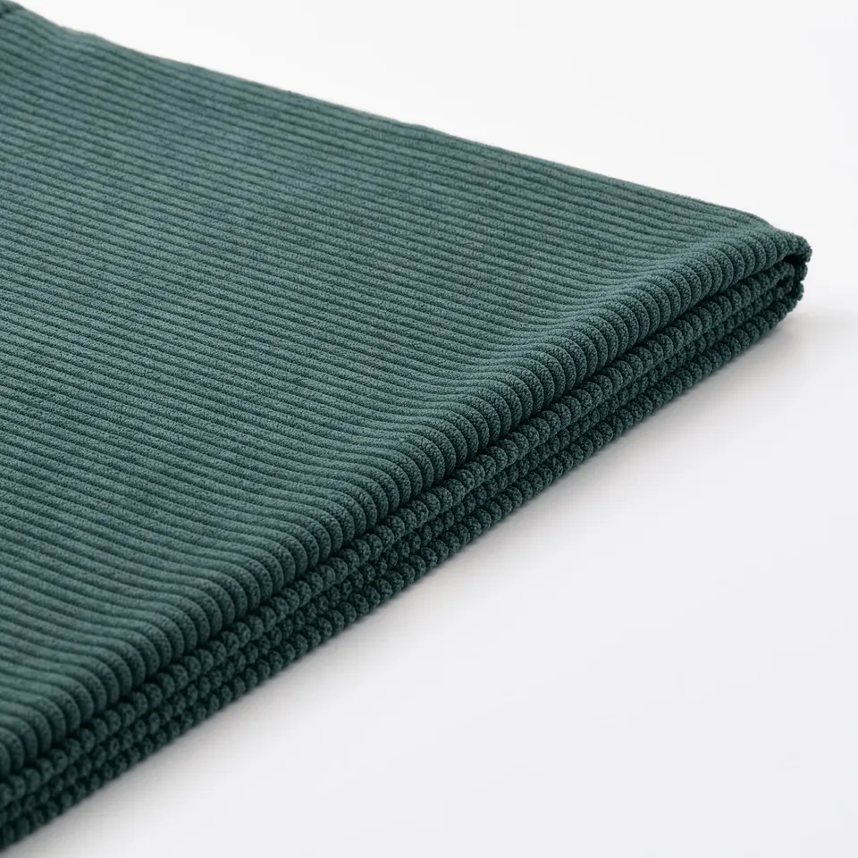 Close-up of green KIVIK sofa fabric, showing its soft, ribbed texture and quality craftsmanship.