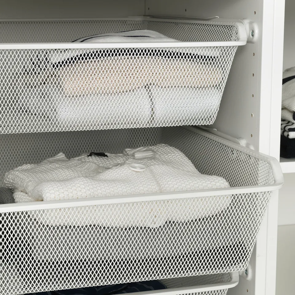 Mesh drawers in white wardrobe, ideal for storing folded clothes, allowing air circulation.