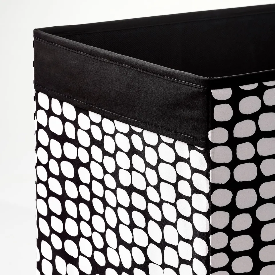 Black fabric storage bin with white oval pattern, sturdy stitching, and handles.