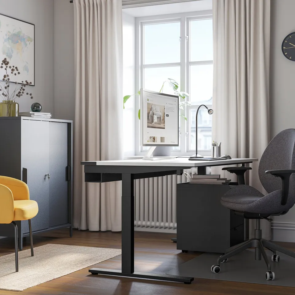 Home office with MITTZON black desk, grey & yellow chairs, large window, white curtains.