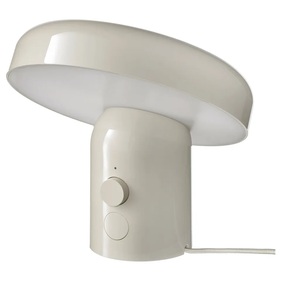 A white BLOMPRAKT lamp with a round shape and a unique design. It has a dimmable light and modern controls on the base.