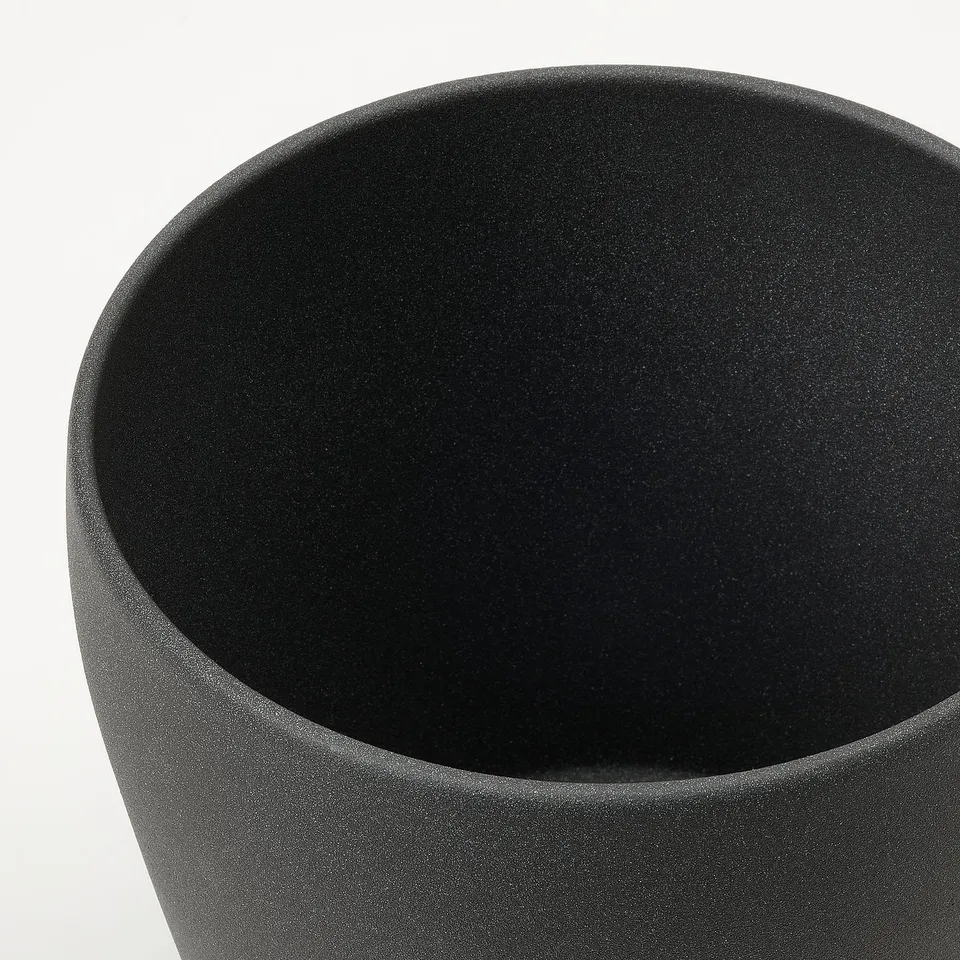 Dark, matte, modern planter. Rounded shape, smooth texture. Ideal for home decor.
