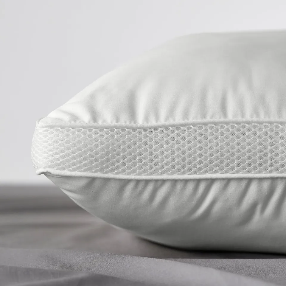 Close-up of a white, high-loft pillow with breathable mesh panels and smooth, seamless fabric.