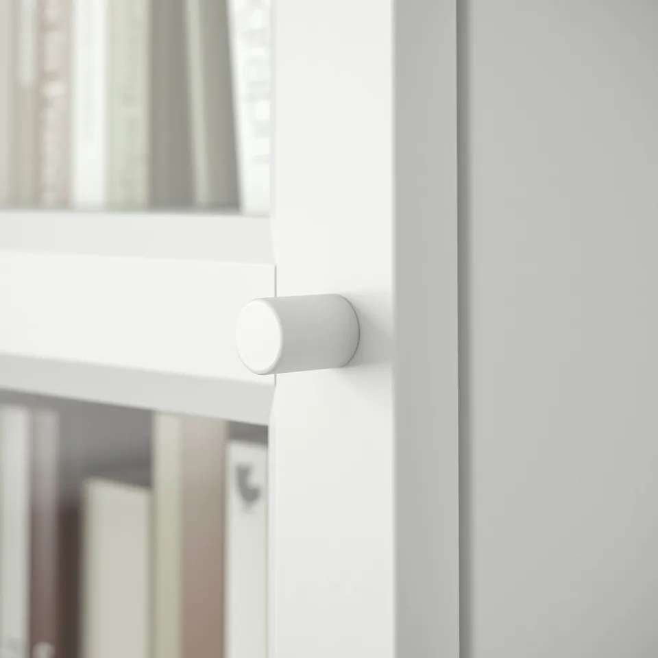 Small white cylindrical device mounted on white cabinet. Modern design, rounded edges.