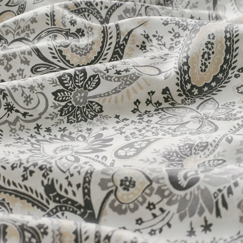 Paisley-patterned pillowcase, neatly folded, showcasing intricate designs. High-quality fabric blend, soft and inviting texture.