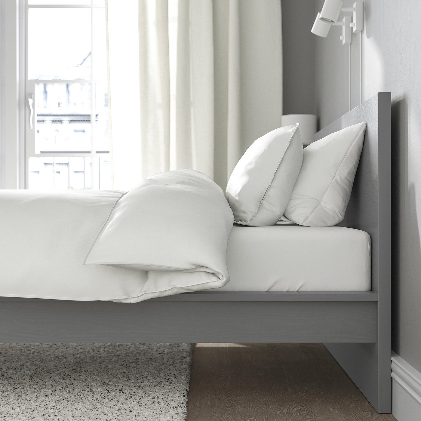 Bedroom scene with MALM bed, crisp white linens, and a window offering city views.