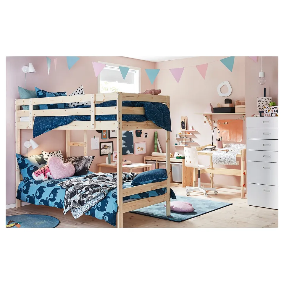 Childs room a wooden bunk bed with blue bedding, pink accents, and a desk with drawers.