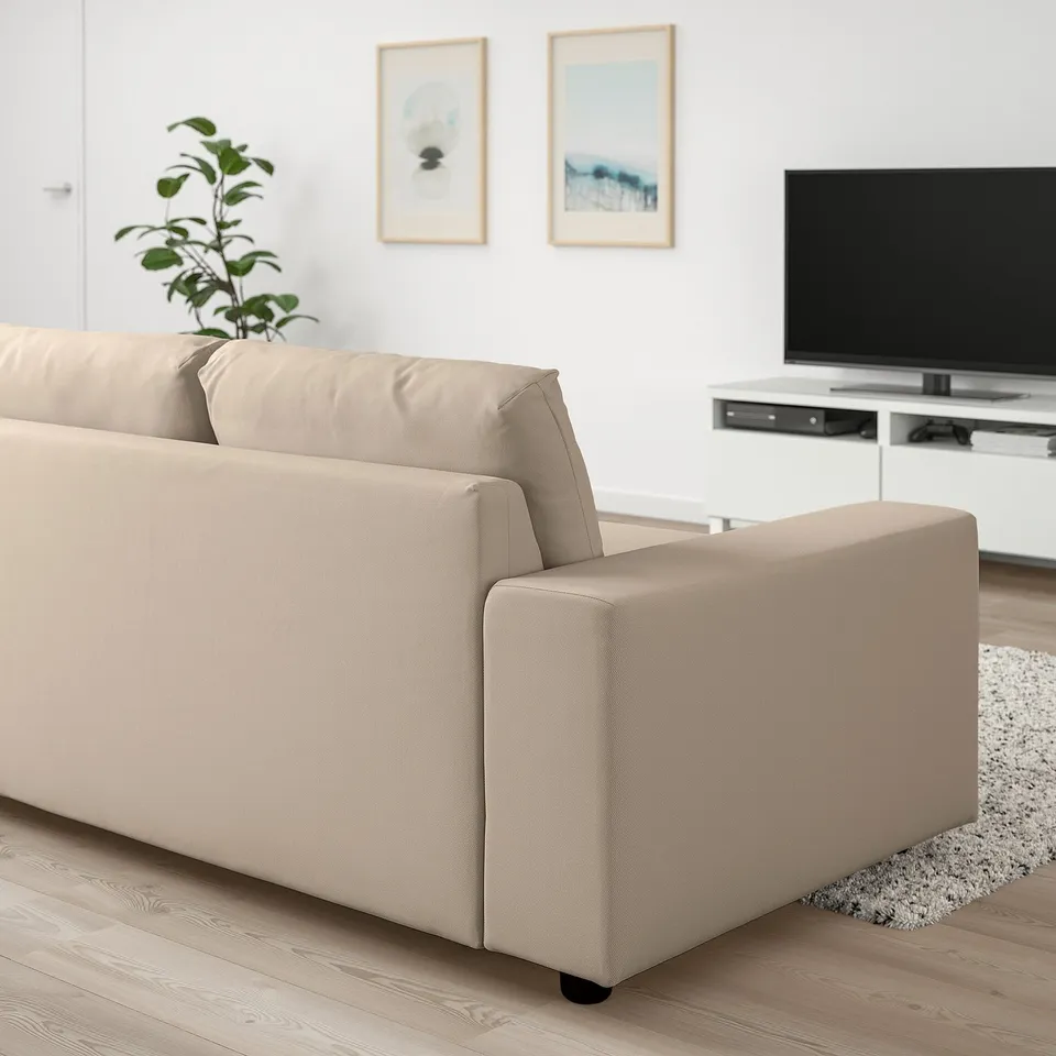 Modern living room with VIMLE beige sofa, tv, rug, plant, and art. Sofa is large, fits well with tv stand.