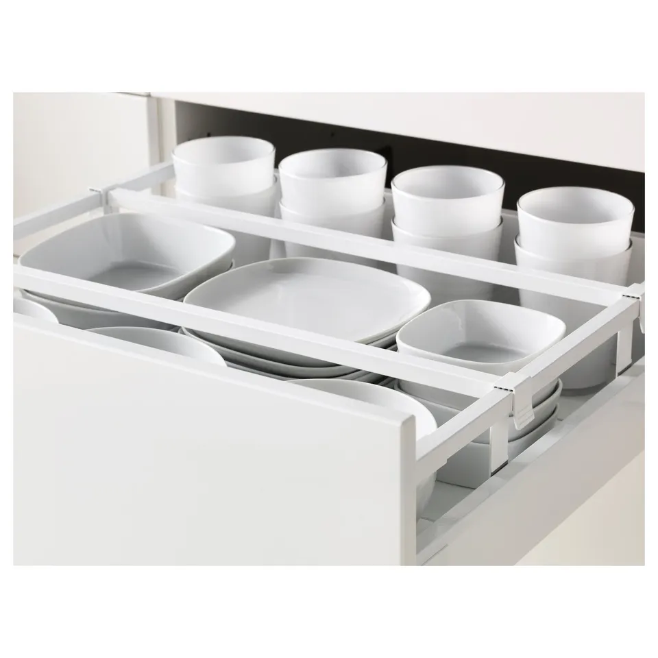 White kitchen drawer organiser with multiple compartments, holding plates, bowls, and cups.