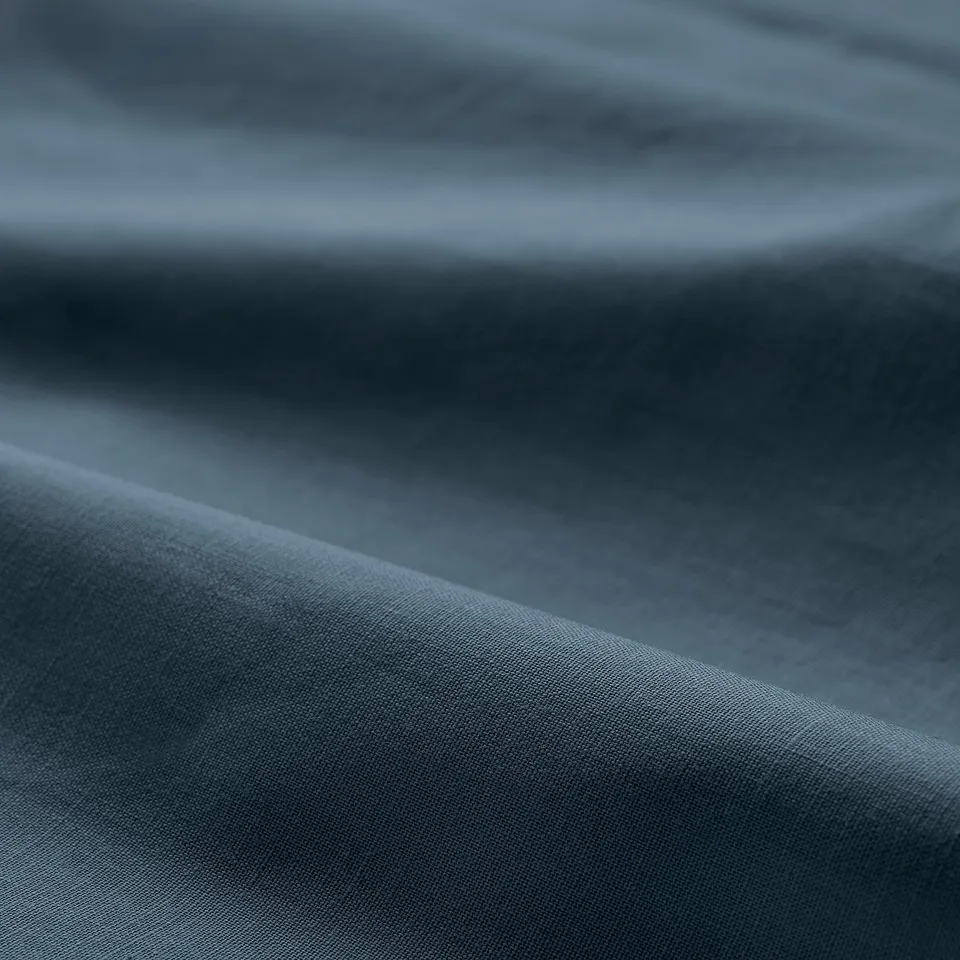 Soft, textured fold of dark blue DVALA cotton sheet, showcasing its smooth, high-quality fabric.
