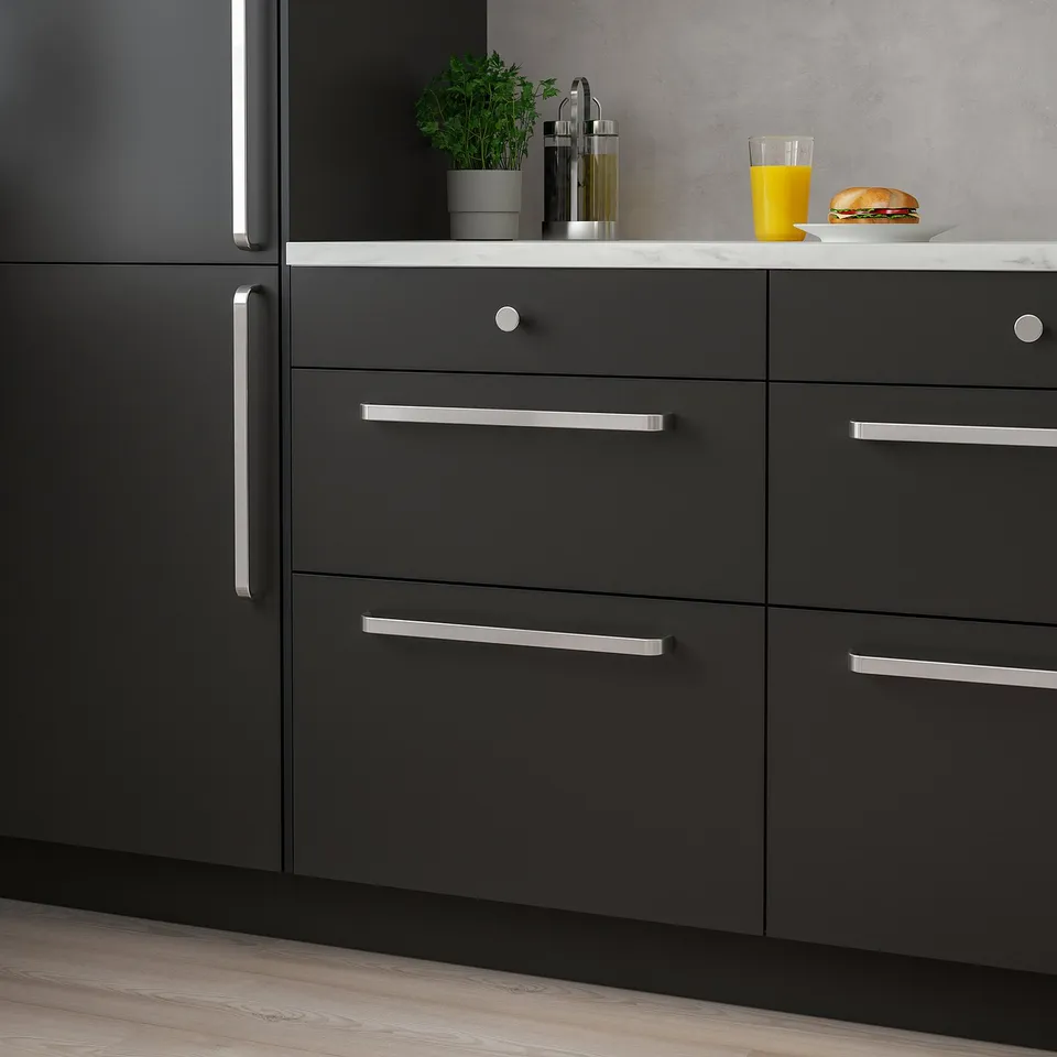 Modern kitchen with KALERUM grey handles, sleek and elongated, placed on dark cabinets, complementing a clean countertop decor.