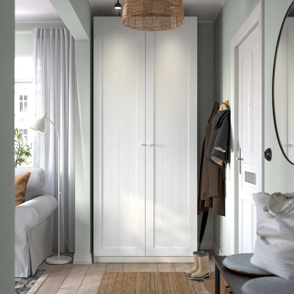 Modern entry: tall white wardrobe, grey walls, wooden floor. Wardrobe, sofa by window.