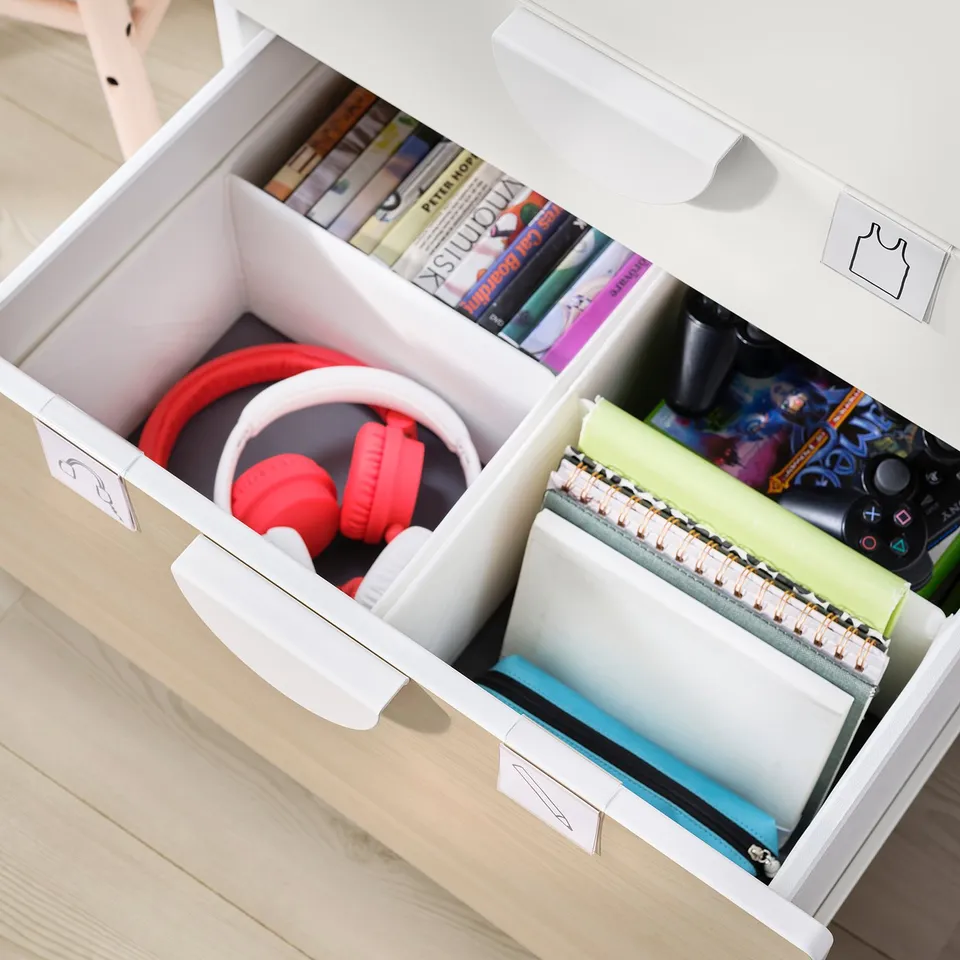 White SMÅSTAD drawers with red headphones, notebooks, and books organised inside.