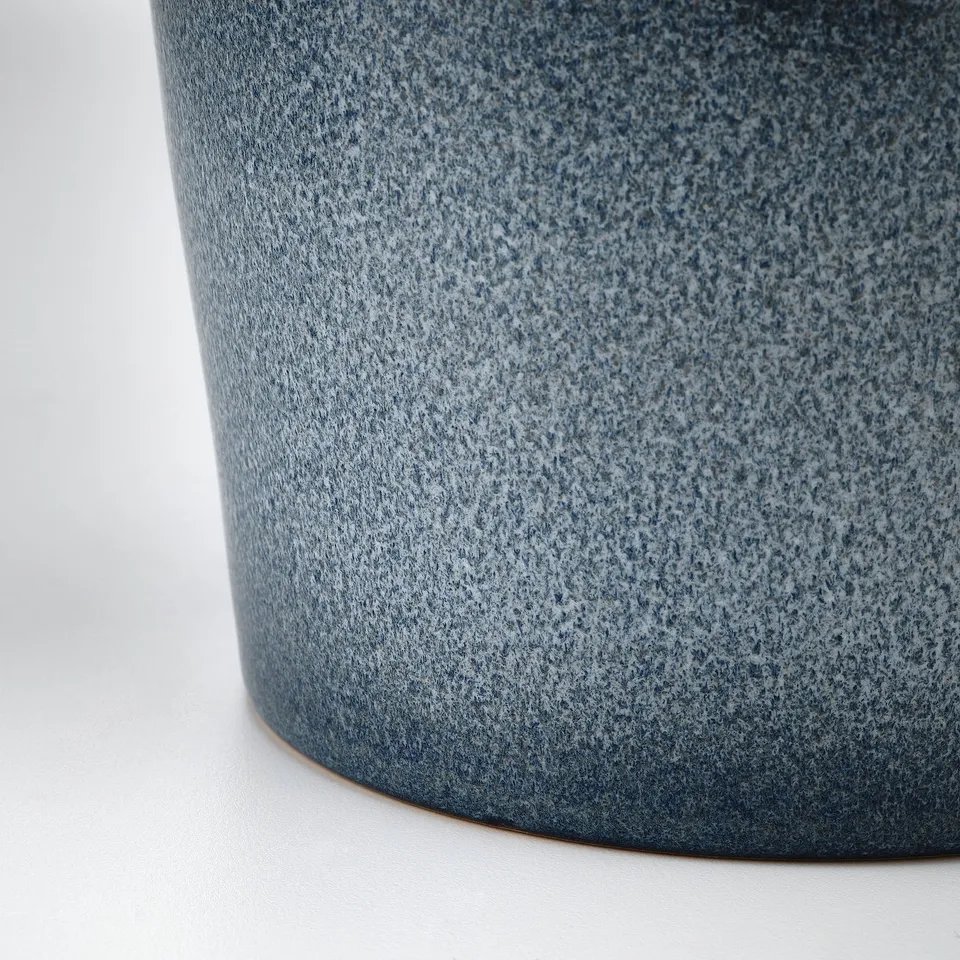 Close-up of textured, dark blue pottery showing fine craftsmanship and detail.