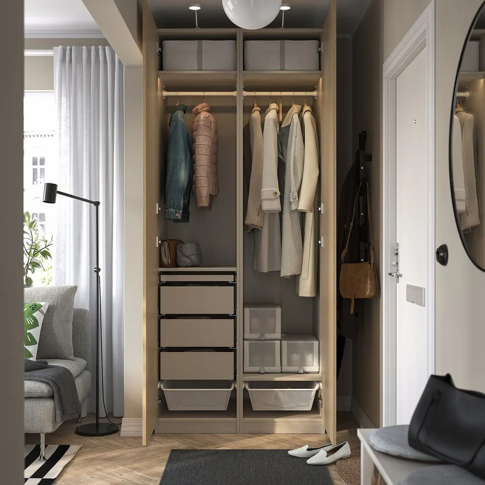 Organised wardrobe showcasing hanging coats, drawers, and storage boxes, reflecting functional design, adjustable feet, and built-in lighting.