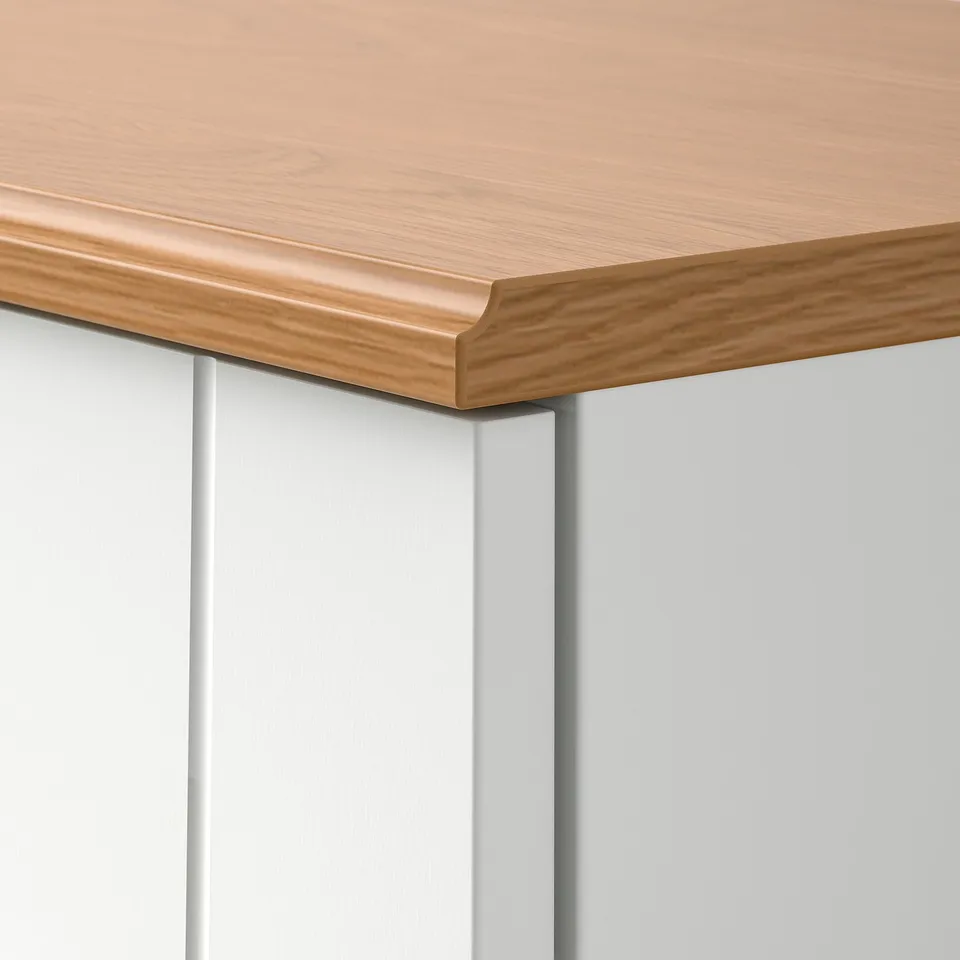 A close-up of a sturdy wooden cabinet with a smooth, oak-finished top and paned white sides. The craftsmanship ensures durability and clean lines.