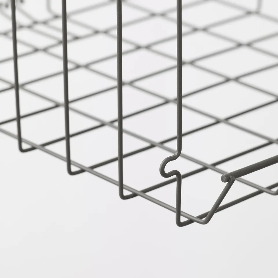 Close-up of sturdy, grid-patterned wire basket with curved handles.