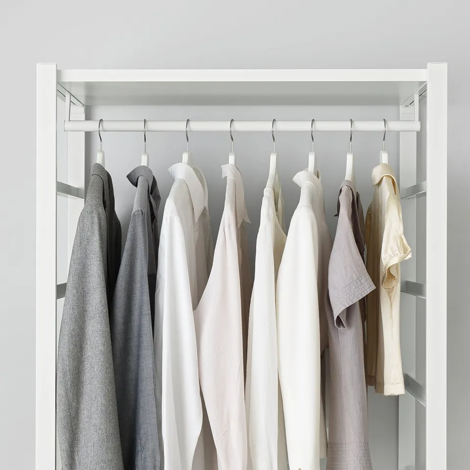 ELVARLI closet with adjustable shelves, holding various hanging garments in different colours. Soft closing drawer mechanism visible.