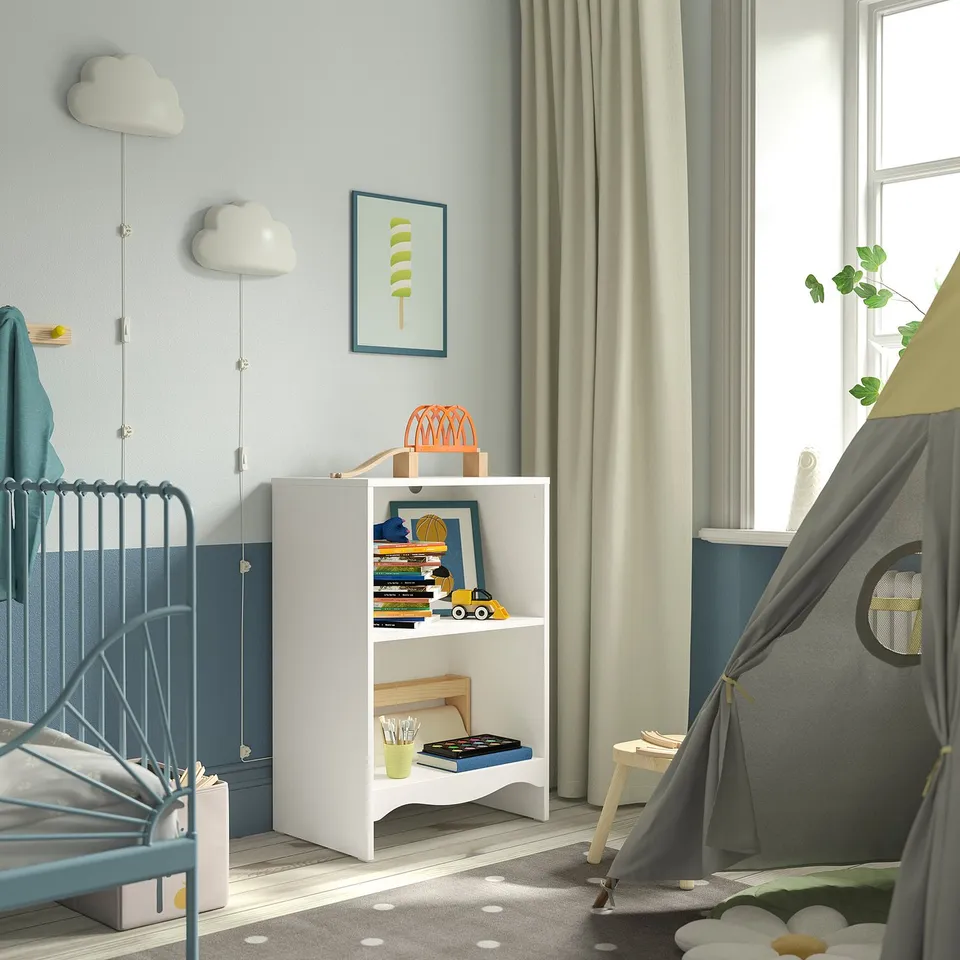 Childs room with white SMÅGÖRA changing table, blue crib, & grey tent. Decorative cloud lights & bookshelf with toys.