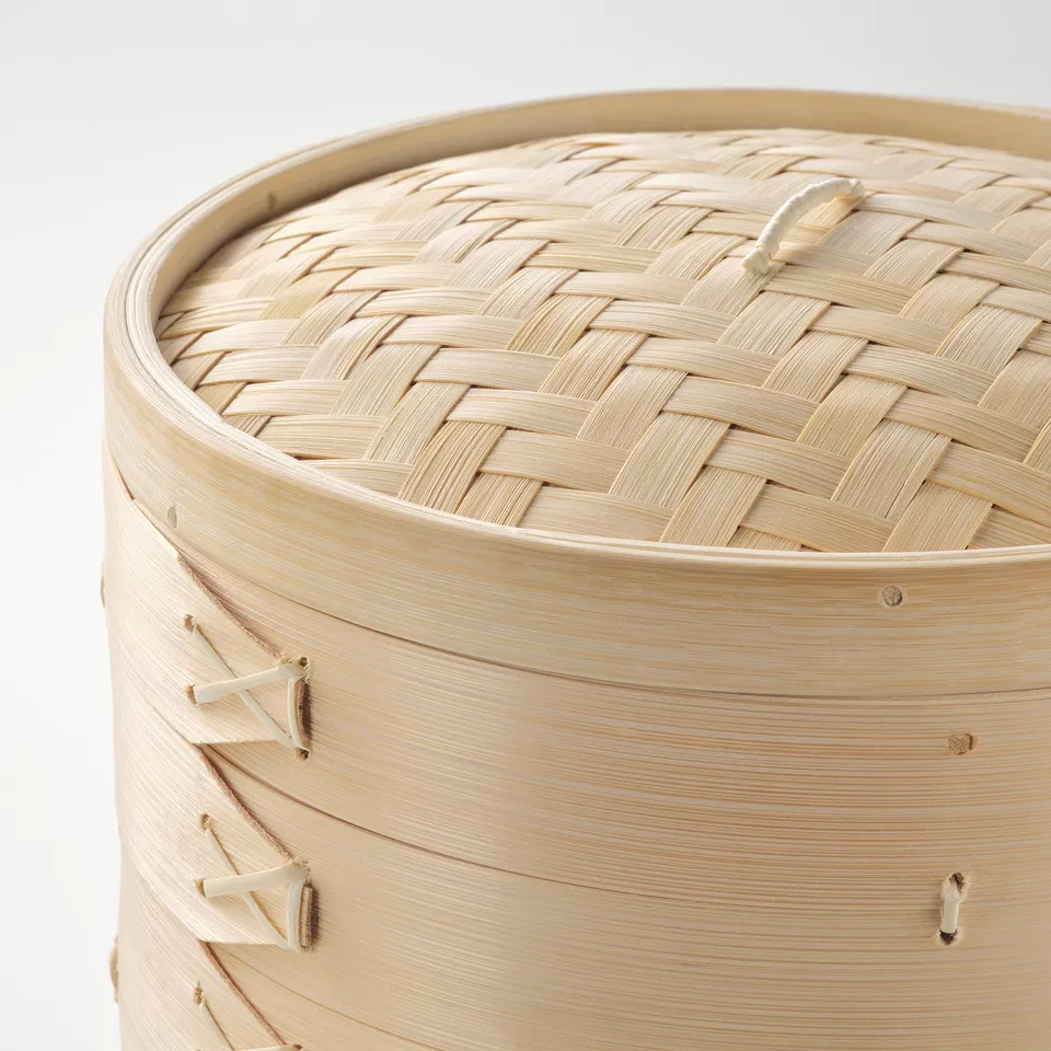 Bamboo steamer basket with lid, woven tightly, showcasing natural wooden texture and sturdy design.