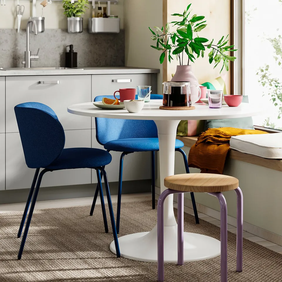 KRYLBO blue upholstered dining chair, modern design, small in size compared to table.