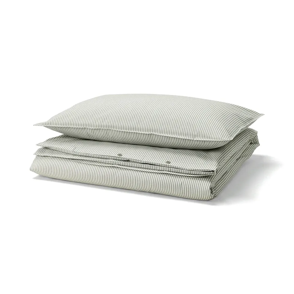 A SOLFIBBLA duvet cover set featuring green and white striped 100% cotton. Rectangular with yarn-dyed stripes, it exudes a soft, vintage charm.