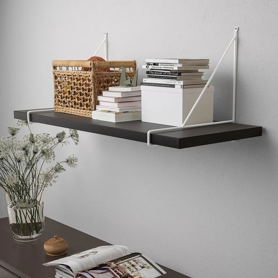 Wall-mounted shelf, holding books, basket, and box. Brackets support and stabilise the shelf.