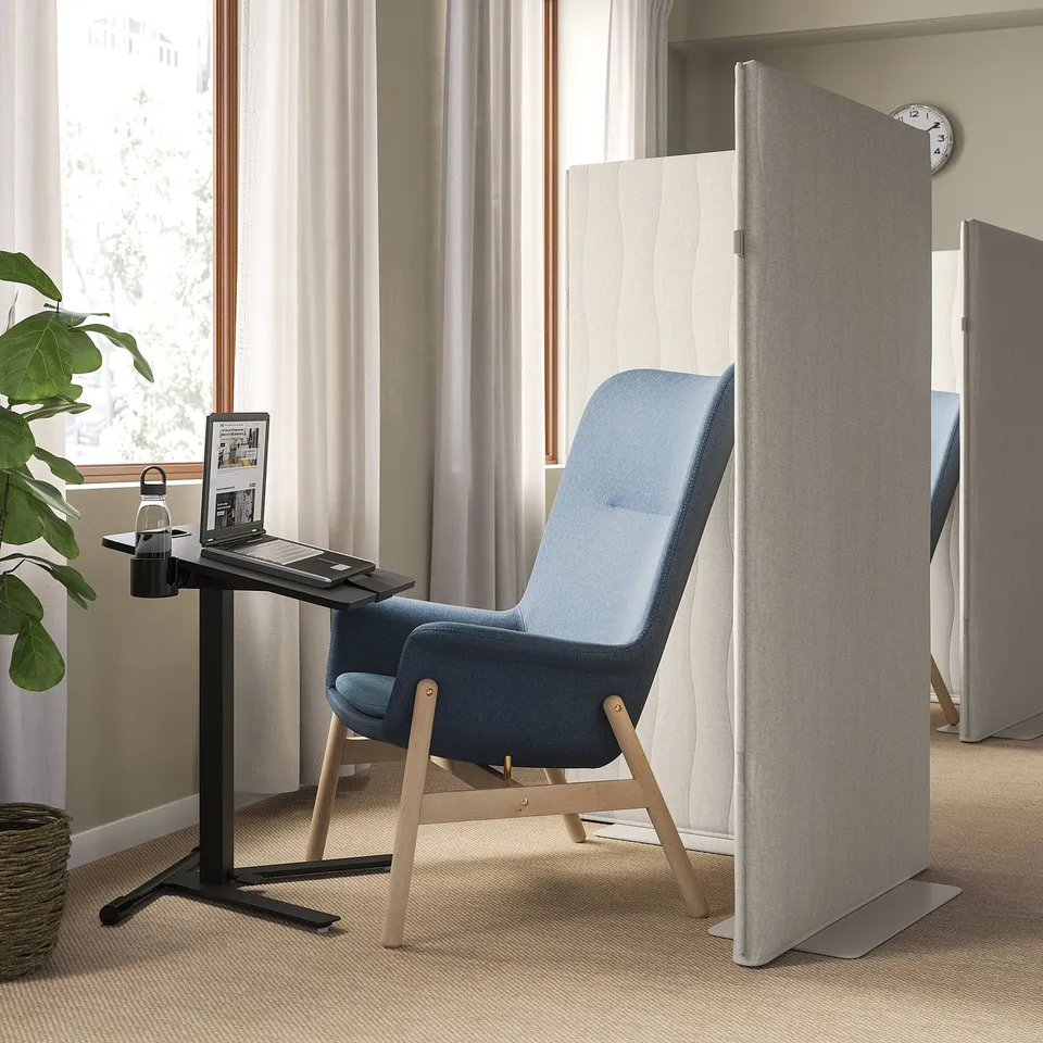 MITTZON blue foldable laptop table in conference room with partition, laptop, and plant.