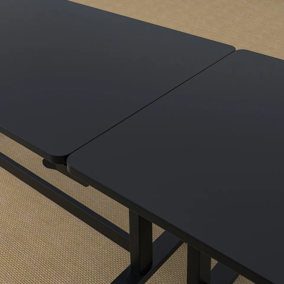 Black folding conference table with castors, designed for easy movement and storage, displayed in a bright room.