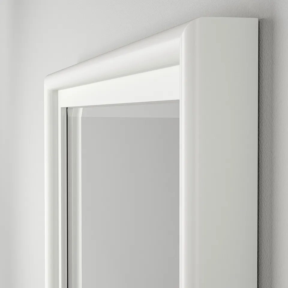 Elegant white-framed mirror with bevelled glass edges, mounted on a pristine wall.