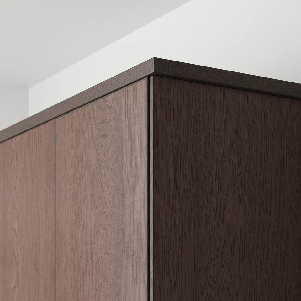Wooden kitchen cabinet fronts with dark oak finish. Visible solid edging outlines the panels, adding warmth and detail.