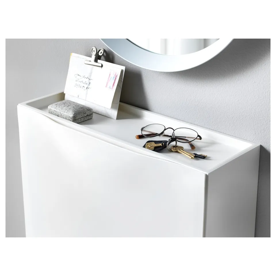 Small white cabinet with glasses, keys, and notes on top, ideal for entrance storage.