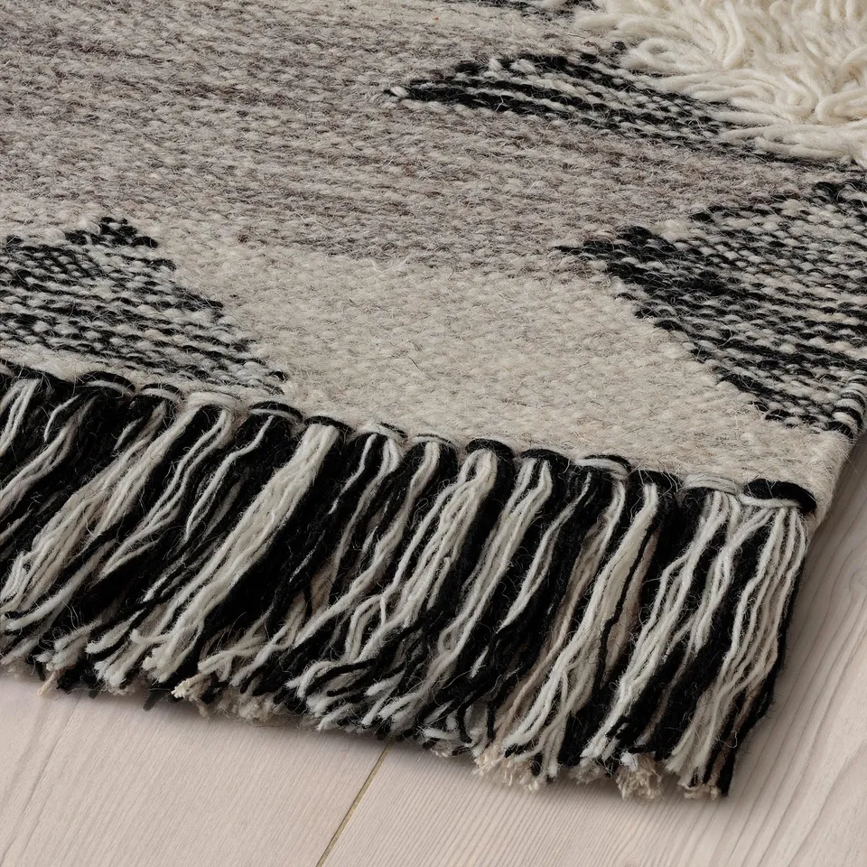 Black and white striped rug with fringe, handmade, wool and cotton, high texture, durable, traditional design.