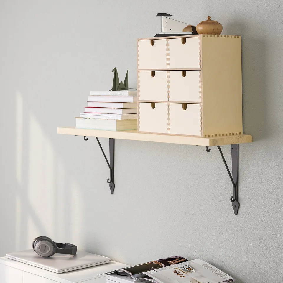 Wall-mounted wooden shelf with multiple compartments, holding books and small items, efficiently using vertical space.