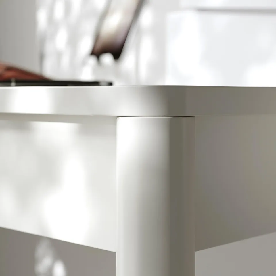 Modern white desk with sleek edges and sturdy support, revealing smooth finish and quality craftsmanship.