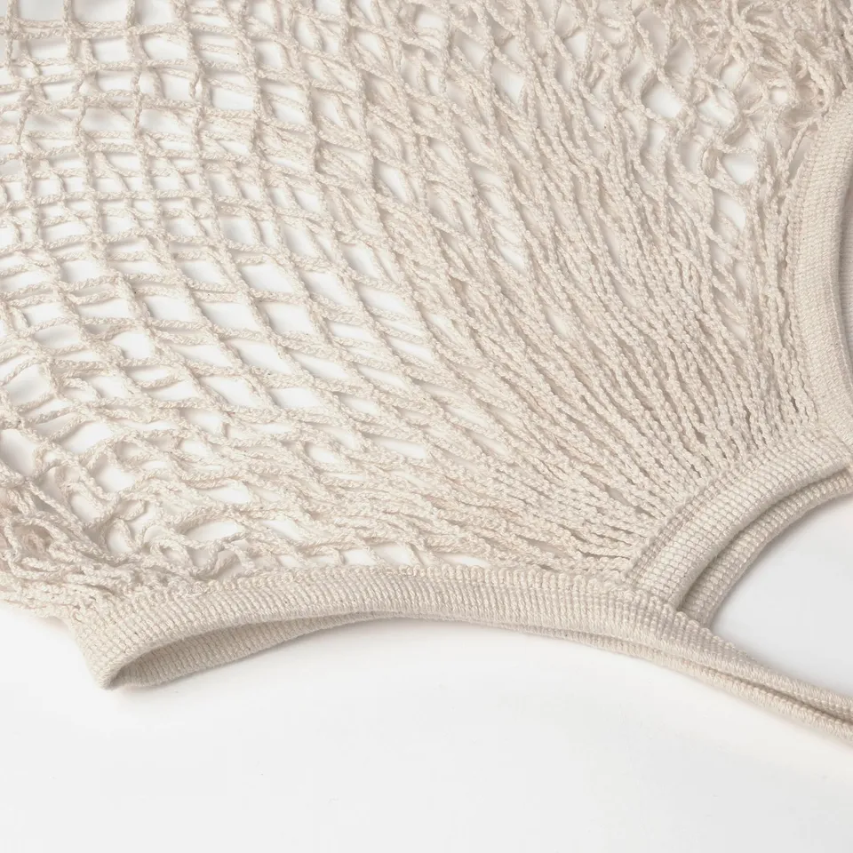 Close-up of KUNGSFORS net bag in cotton. Intricate weave pattern, natural colour, durable material.