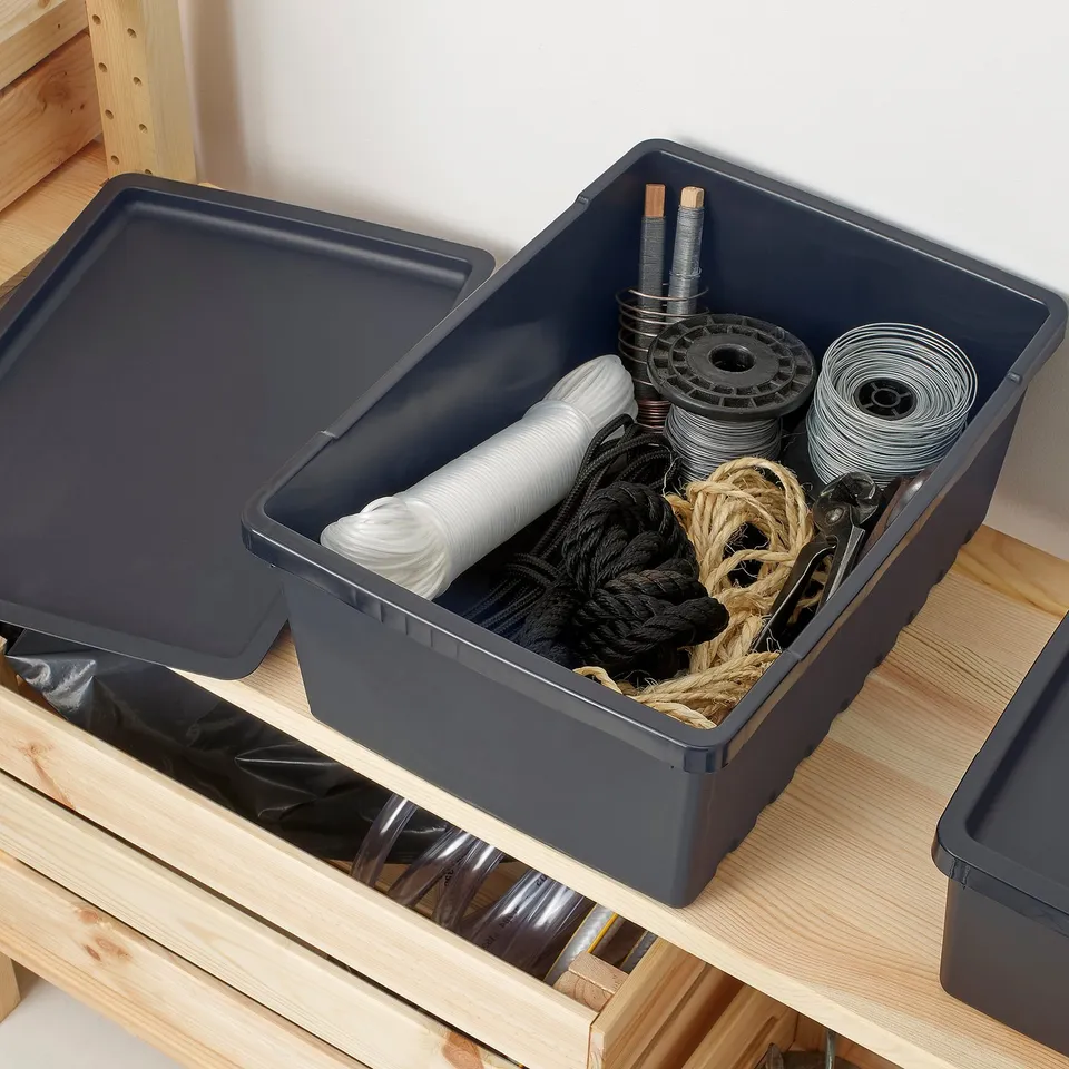 Plastic storage bin on shelf, holding ropes and tools.