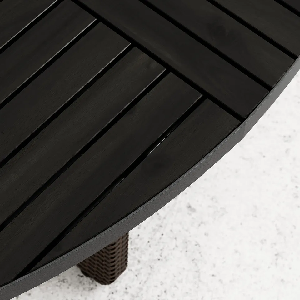 Dark wooden table with horizontal slats sits on a woven base. Surface is smooth, well-crafted, and appears durable. Corner displayed.