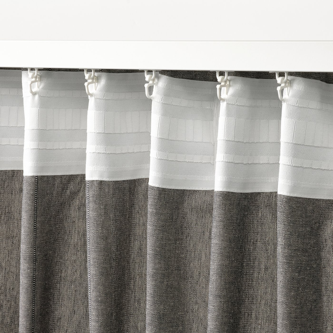 Curtains with header tape for easy hanging, allowing privacy while letting daylight through. Hooks along top for tiebacks.