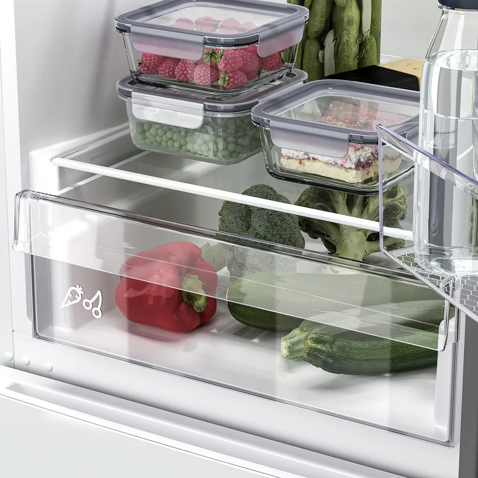 Fridge with adjustable bins and led light showing veggies.
