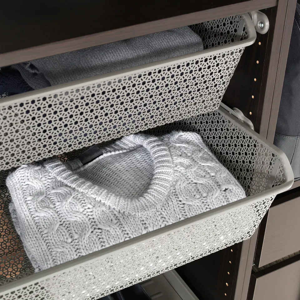 Metal wardrobe basket with sweater. Holds folded clothes, improves air circulation.