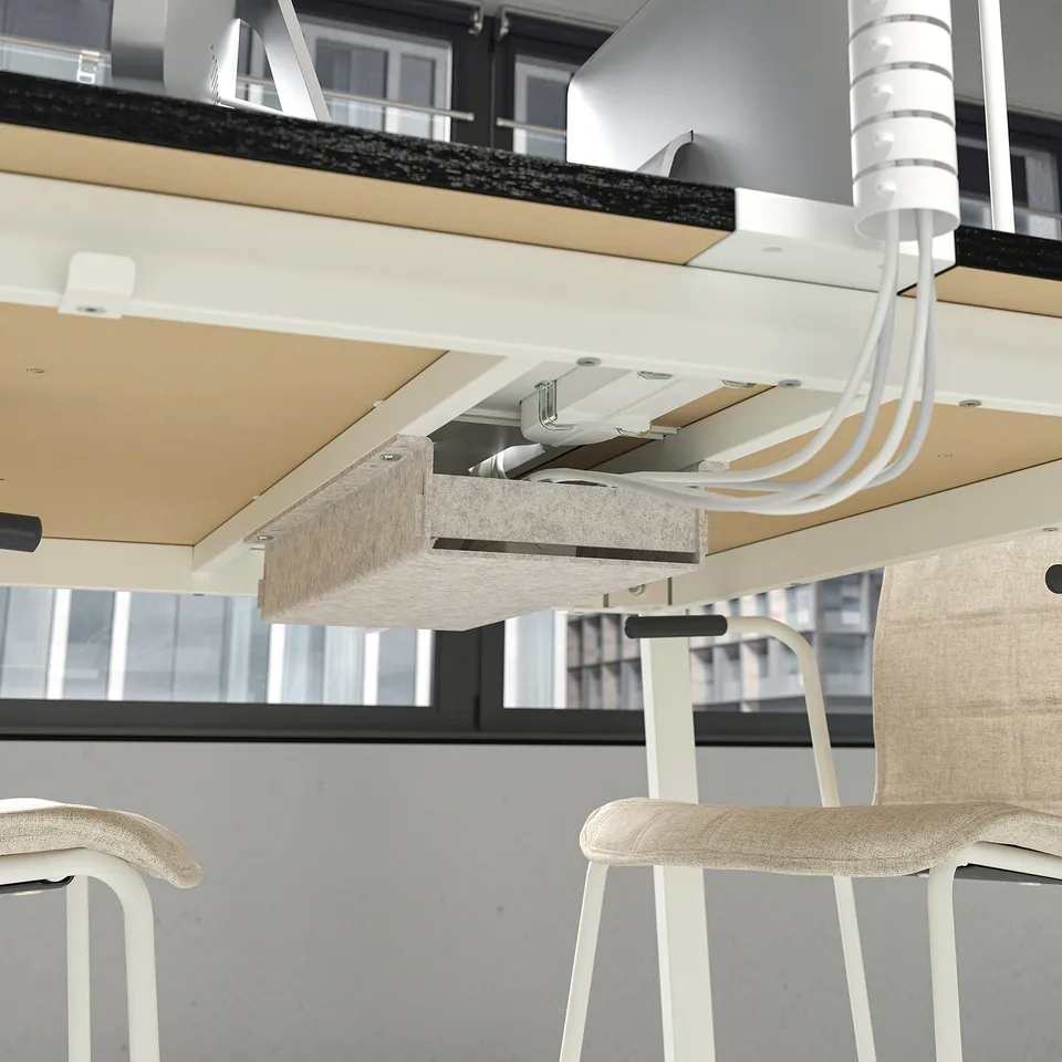 Office table with adjustable height, footrest, and cable management.
